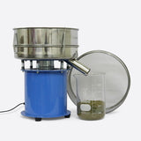 Commercial automatic sifting machine (blue/silver) with multiple sieves, a spout, and a 5000ml beaker filled with green material.