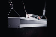 Aelius 300 LED grow light hanging in front of a black background.