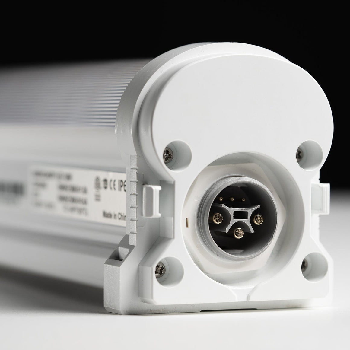 White under-canopy light with IP6 rating and multi-pin connector.