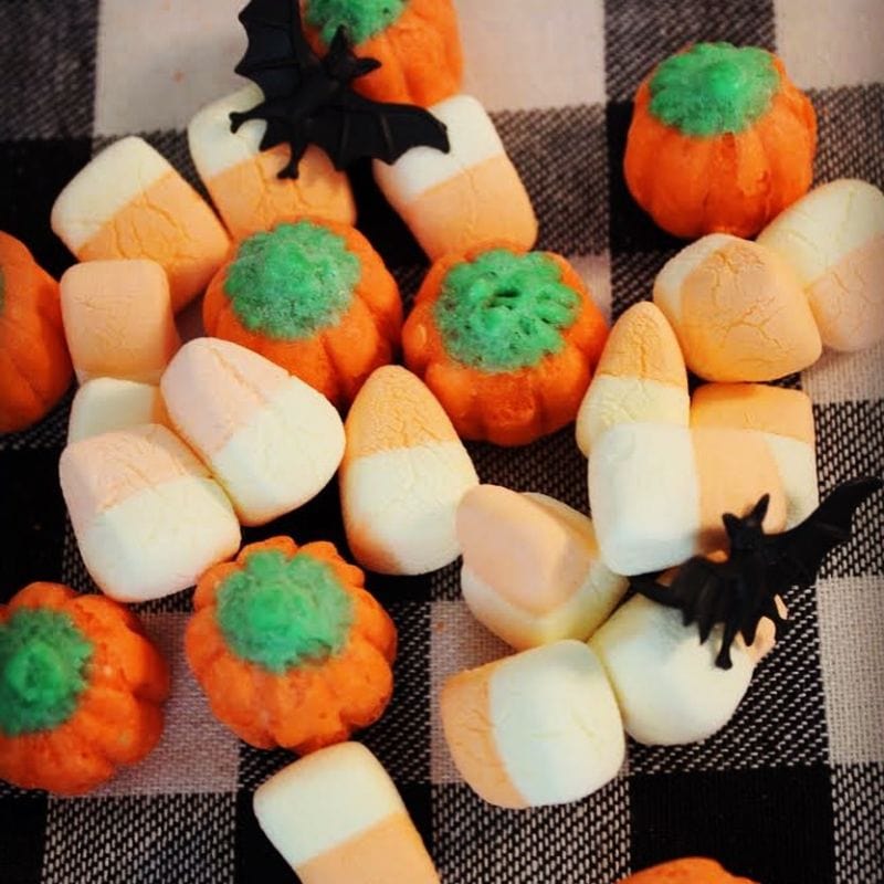 Halloween freeze-dried marshmallows: pumpkins, candy corn, and two-tone squares with black bats on checkered fabric.