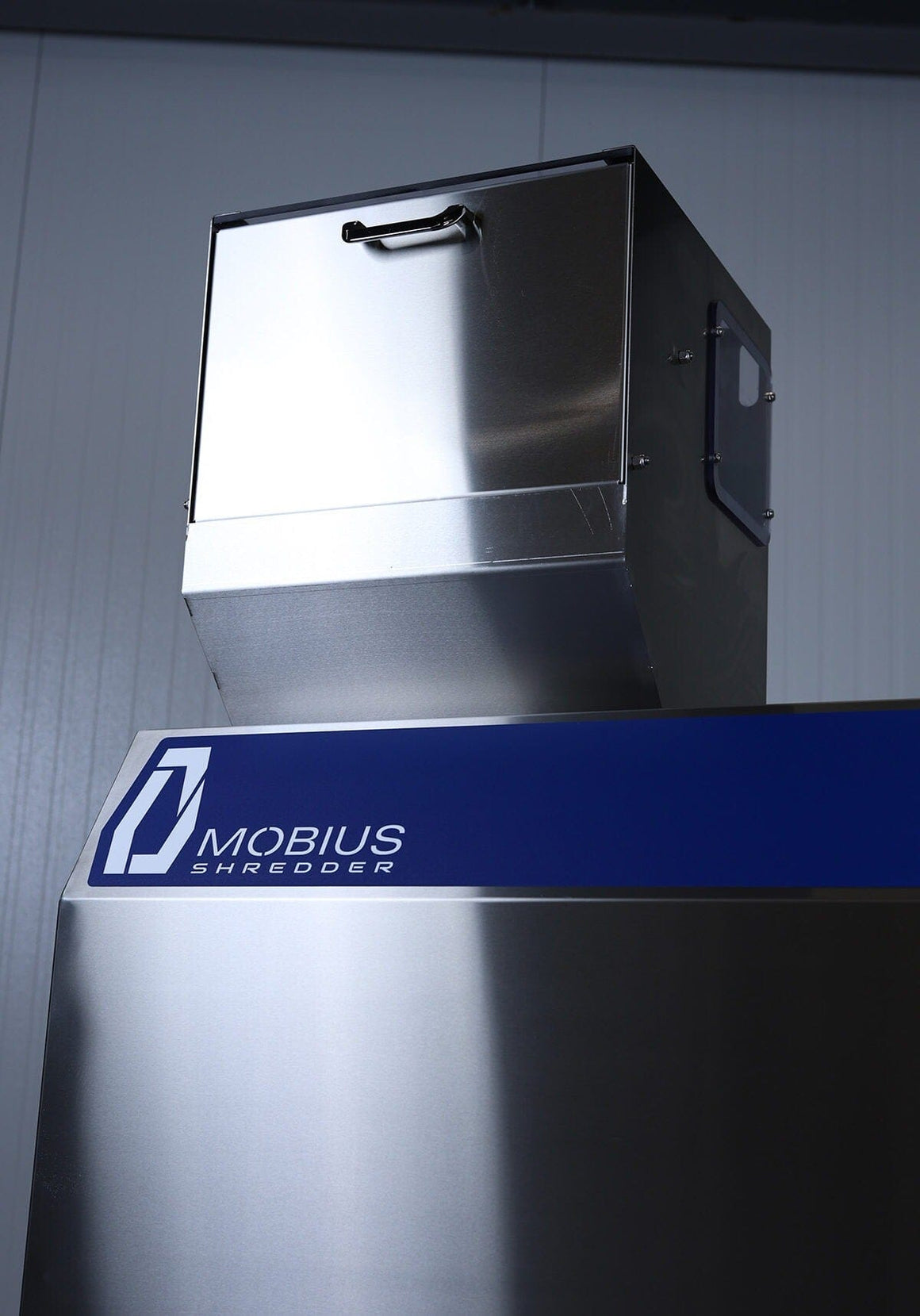 Close-up of a Mobius industrial shredder with logo on a blue band.