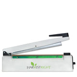 White Harvest Right 12-inch impulse sealer with a green sealing bar and black handle, shown open.